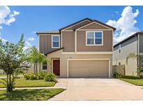 Charming two-story home features a neutral color scheme, well-maintained landscaping, and an attached two-car garage at 22359 Storybook Cabin Way, Land O Lakes, FL 34637