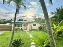 Charming single-story home featuring lush landscaping, stepping stone pathway, and freshly cut grass at 2707 56Th S St, Gulfport, FL 33707