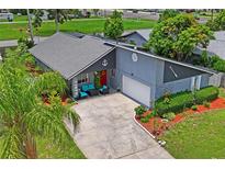 Charming home featuring unique nautical-themed decor, red front door, front patio, and a spacious driveway at 3113 Chamblee Ln, Clearwater, FL 33759