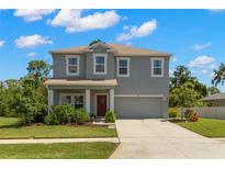 Charming two-story home with manicured lawn, mature landscaping, and a two-car garage at 3115 Gina Ct, Holiday, FL 34691