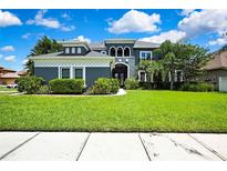 Beautiful two-story home with a lush green lawn and manicured landscaping at 3241 Evening Breeze Loop, Wesley Chapel, FL 33544