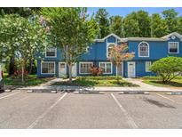Beautiful blue townhome featuring well-maintained landscaping and resident parking at 3323 Fox Hunt Dr, Palm Harbor, FL 34683