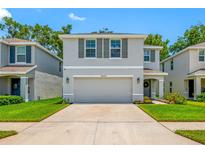 Charming home featuring a two-car garage, beautiful landscaping, and a welcoming front porch at 36652 N Spanish Rose Dr, Dade City, FL 33525