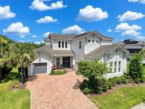 Beautiful two-story home with a brick driveway, lush landscaping, and a charming front porch at 4080 Bonfire Dr, Odessa, FL 33556