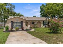Charming single-story home with an arched entryway, landscaped front yard, and concrete driveway at 5112 Odin St, Spring Hill, FL 34608