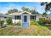 Charming single-story home with a blue front door, white siding, and lovely landscaping at 716 35Th W St, Bradenton, FL 34205