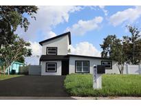 Charming two-story home featuring black trim windows, a landscaped yard, and a freshly paved driveway at 8274 Rose Ter, Seminole, FL 33777
