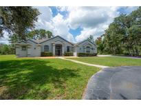 Charming single-story home with well-manicured lawn and mature trees in a picturesque setting at 23268 Family Ln, Brooksville, FL 34602