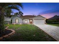 Charming single-story home features a well-manicured lawn, brick-lined driveway, and attached two-car garage at 11251 Pickford St, Spring Hill, FL 34609