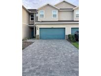 Charming townhome with a paved driveway and two-car garage offering great curb appeal at 11634 Woodleaf Dr, Bradenton, FL 34211