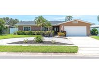 Charming single-story home with well-manicured lawn, lush landscaping, and a welcoming driveway at 14060 102Nd Ave, Largo, FL 33774