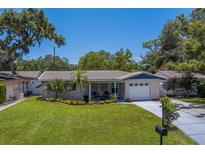 Charming single-story home with manicured lawn, tile roof, and attached garage at 2123 Indigo Dr, Clearwater, FL 33763