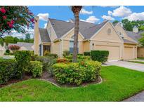 Charming townhome with a well-maintained lawn, beautiful landscaping, and a beige exterior at 3602 Pine Knot Dr # 0, Valrico, FL 33596