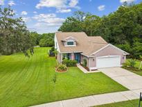 Charming single-Gathering home featuring well-manicured lawn, attached garage, and inviting curb appeal at 422 Cypress View Dr, Oldsmar, FL 34677