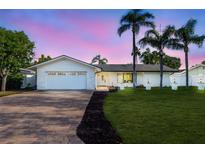 Charming home with a well manicured lawn and brick driveway and front entrance and attractive landscaping at 4495 Clearwater Harbor S Dr, Largo, FL 33770