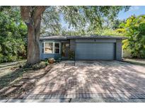 Charming single-story home featuring a brick driveway, well-kept landscaping, and attached two-car garage at 6 Harbor Cove St, Safety Harbor, FL 34695
