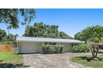 Charming single-story home featuring a metal roof, attached garage, and mature landscaping in a residential neighborhood at 675 69Th S Ave, St Petersburg, FL 33712
