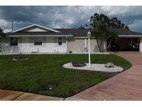 Charming single-story home with well-maintained lawn, mature palm trees, and an attached garage at 702 Cypress Pl, Sun City Center, FL 33573