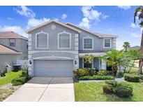 Charming two-story home with a well-maintained lawn, complemented by a paved driveway and lush landscaping at 7515 Dragon Fly Loop, Gibsonton, FL 33534