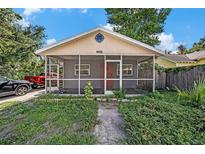Charming single-story home featuring a screened porch, brick facade, and lovely landscaping at 8606 N 9Th St, Tampa, FL 33604