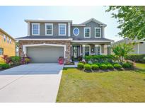 Charming two-story home features a manicured front yard, stone accents, and a two-car garage at 11044 Spring Point Cir, Riverview, FL 33579