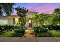 Charming home showcasing lush landscaping, a brick walkway, and a cozy covered entry at 11317 Wickersley Pl, Tampa, FL 33625