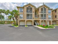 Beautiful building exterior featuring multiple garages, screened patios, and professional landscaping at 2201 Bay Club Cir, Tampa, FL 33607