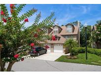 Charming townhouse with a two-car garage and inviting curb appeal, enhanced by flowering trees and lush landscaping at 2804 Countryside Blvd # 4, Clearwater, FL 33761