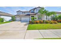 Charming two-story home with a three-car garage, a lush lawn, and vibrant landscaping at 2866 Quail Crest Ct, Valrico, FL 33594