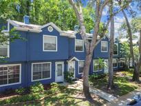 Bright blue two-story townhome with white trim and lush green trees at 3335 Fox Hunt Dr, Palm Harbor, FL 34683