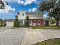 Charming two-story home featuring a brick facade, a balcony, a well-maintained lawn, and a large driveway at 425 49Th N St, St Petersburg, FL 33710