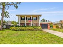 Two-story home featuring a lovely lawn, brick accents, and an attached garage and rooftop patio at 4915 Stolls Ave, Tampa, FL 33615