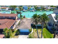 Charming single-Gathering home featuring a tile roof, two-car garage, and palm trees in a waterfront community at 501 Crystal Dr, Madeira Beach, FL 33708