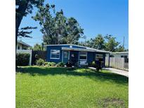Charming blue single-story home featuring a lush green lawn and welcoming front porch at 5136 13Th S Ave, Gulfport, FL 33707