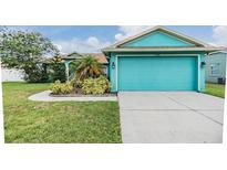 Eye-catching, vibrant blue single-Gathering home featuring a two-car garage and well-manicured lawn at 7046 Frascati Loop, Wesley Chapel, FL 33544