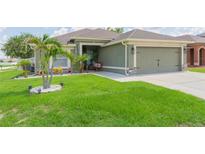 Well-manicured lawn complements this charming home, complete with a two-car garage and inviting front entryway at 11913 Butler Woods Cir, Riverview, FL 33579