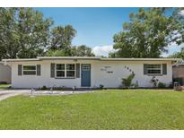 Charming single-story home featuring a well-maintained lawn and a blue front door at 1438 Poinciana Dr, Clearwater, FL 33764