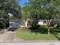 Charming single-story home with a well-manicured lawn and mature trees, offering great curb appeal at 1875 Harmony Dr, Clearwater, FL 33756