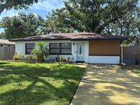 Charming single story home with a well-maintained lawn and wood accent wall at 3120 Meadow Lake Ave, Largo, FL 33771