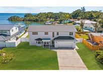Stunning waterfront property featuring a modern two-story home with a lush lawn at 380 Colony Point S Rd, St Petersburg, FL 33705