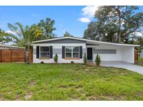 Charming single-story home with well-manicured lawn, palm tree, and attractive gray and white exterior at 4020 N Falkenburg Rd, Tampa, FL 33610