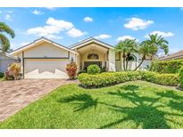 Beautiful home featuring well-manicured landscaping, palm trees, and a brick driveway at 5270 White Sand Ne Cir, St Petersburg, FL 33703