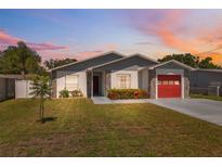 Charming single-story home featuring a red garage door, stone accents, and well-maintained landscaping at 6209 S Harold Ave, Tampa, FL 33616