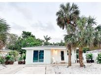 Charming single-story home with palm trees and a white gravel yard creating an inviting curb appeal at 690 Fox St, Longboat Key, FL 34228