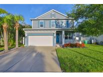 Charming two-story home featuring a two-car garage, inviting front porch, and well-manicured lawn at 7703 S West Shore Blvd, Tampa, FL 33616