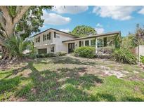 Two-story home featuring a brick and vinyl exterior with landscaped yard, a front-entry two car garage, and large front-yard trees at 8500 144Th Ln, Seminole, FL 33776