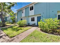 Charming two-story townhome with a well-maintained lawn and blue exterior paint at 110 114Th Ne Ter # 110, St Petersburg, FL 33716