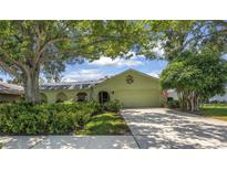 Charming single-story home with a well-manicured lawn and mature trees providing shade at 11250 Tradewinds Blvd, Largo, FL 33773