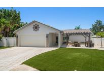 Charming single-story home featuring a two-car garage, pergola, and well-manicured front lawn at 11763 Saree Ct, Largo, FL 33778