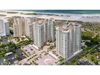 Stunning aerial view of beachfront condo buildings, lush landscaping, and beach access at 1180 Gulf Blvd # 504, Clearwater Beach, FL 33767